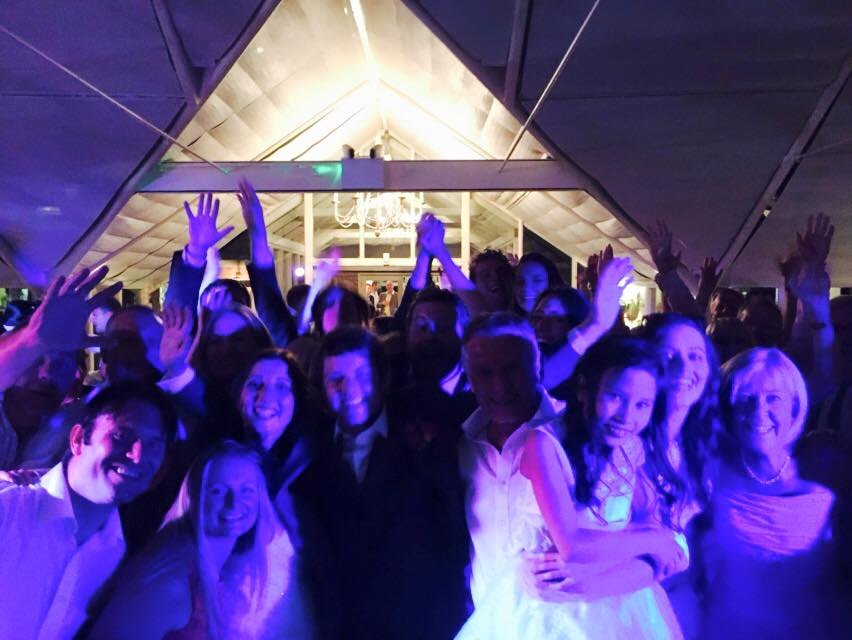 Wedding guests dancing with hands in the air